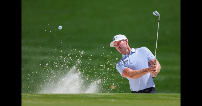 a golfer hitting a shot out of the sand